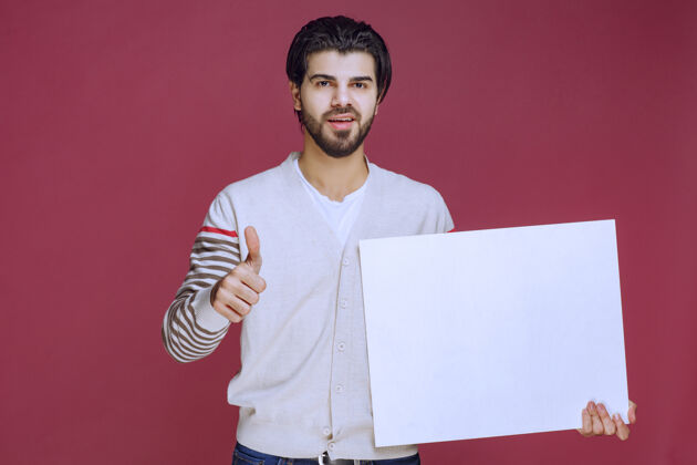 人拿着一块空白的创意板 竖起大拇指的男人喜欢员工年轻人