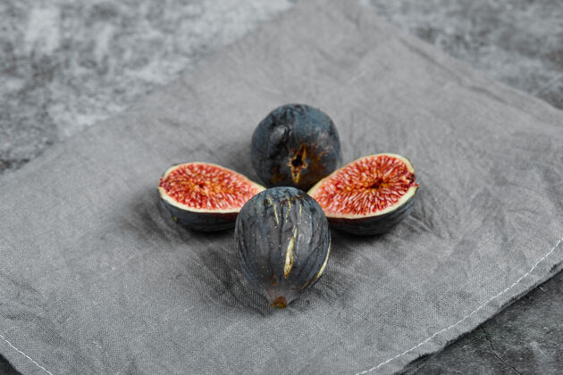 切片四个黑色无花果大理石背景与灰色桌布高品质的照片甜点水果食品