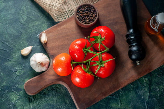 膳食顶视图新鲜的红色西红柿和大蒜在黑暗的表面食物晚餐熟食餐照片色拉健康新鲜新鲜的红色西红柿大蒜