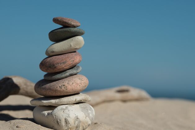 海滩岩石在沙子上完美平衡 展现出和谐的概念关系和谐阳光