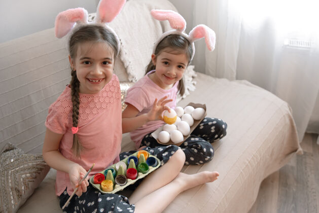 准备小妹妹们在家里的沙发上画复活节彩蛋女孩房子兔子
