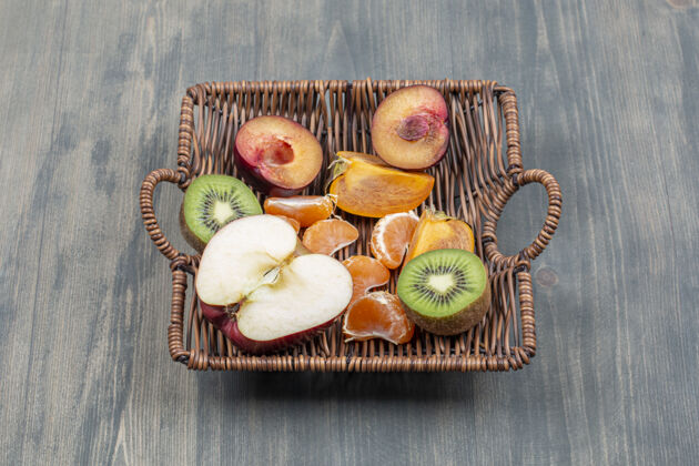 生的木桌上的柳条篮子里有各式各样的水果健康食品成熟营养