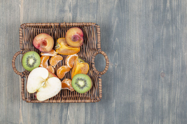 健康食品木桌上的柳条篮子里有各式各样的水果膳食混合苹果