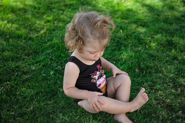 孩子们夏天的小女孩坐在花园的草地上花园休息影子