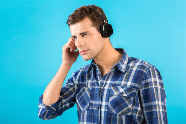 时髦时尚帅气的年轻人戴着无线耳机听音乐年轻姿势扬声器