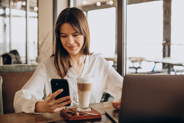 无线年轻的女商人在咖啡馆上网 喝咖啡工作在线学习学习