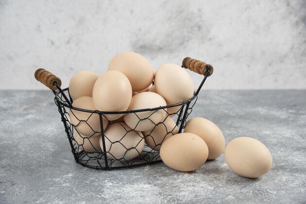 烹饪柳条篮子的生有机鸡蛋放在大理石上食物自然有机