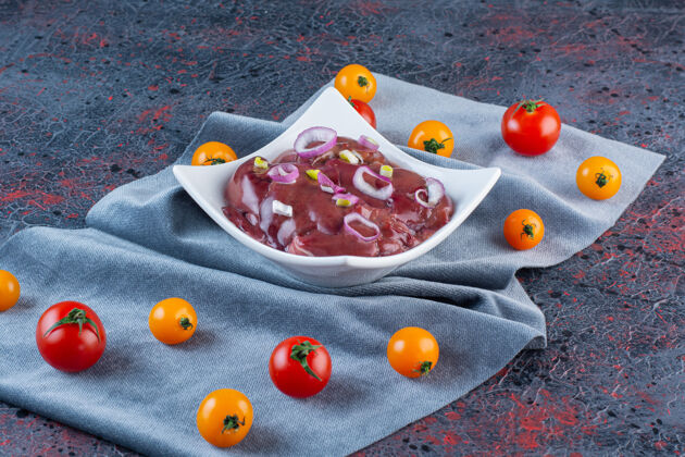 料理白碗肉片配樱桃番茄 大理石背景樱桃部分切片