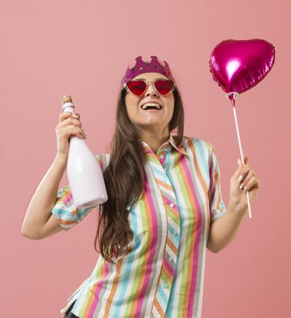 笑脸在派对上用气球和香槟瓶为年轻女子画像节日香槟瓶气球