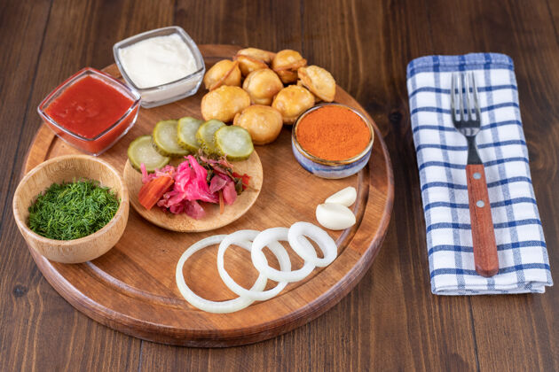 桌布木盘上有油炸饺子 番茄酱和泡菜戒指叉子泡菜
