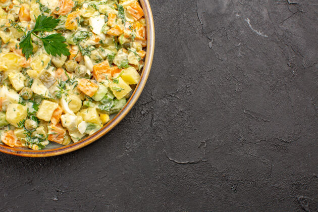 盘子蛋黄酱沙拉的俯视图 深色表面有不同的蔬菜烹饪沙拉种子