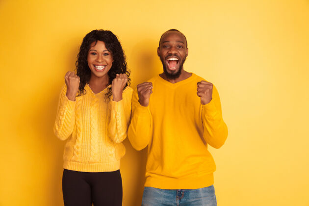 面部年轻感性的非裔美国人 穿着鲜艳的休闲服 在黄色背景上摆姿势美丽的情侣人类情感的概念 面部表情 关系 广告快乐的庆祝人人类男性