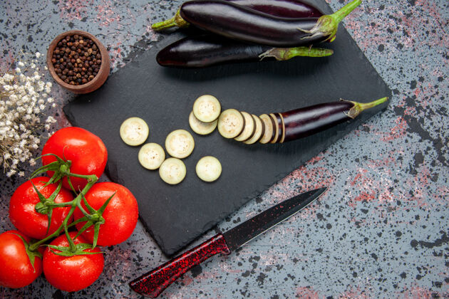沙拉俯视图黑色茄子与新鲜的红色西红柿在蓝色的表面上生长食物晚餐树颜色餐沙拉照片刀片视图用餐