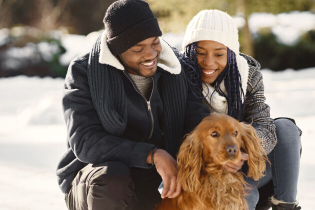 夫妇人们在外面散步冬天非洲夫妇带着狗霜冻女孩白色
