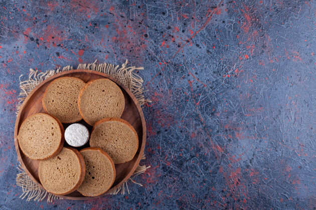 面团把切片的面包和面粉放在木板上 放在布上 放在蓝色的上面风味面包皮糕点