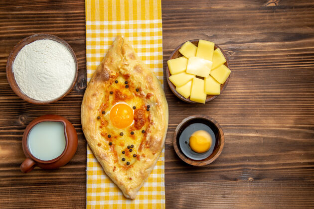 桌子俯视图美味的鸡蛋面包 刚从烤箱里拿出来 放在木头桌子上的牛奶和奶酪 面包 鸡蛋面包风景小面包盘子