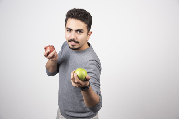 食物黑发男人拿着青苹果和红苹果人类男孩模型