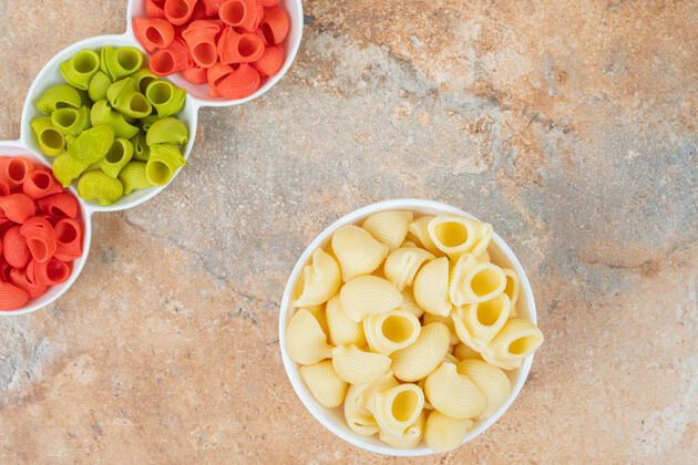 营养绿色 红色和黄色的意大利面管放在碗里 放在大理石上意大利面美味通心粉