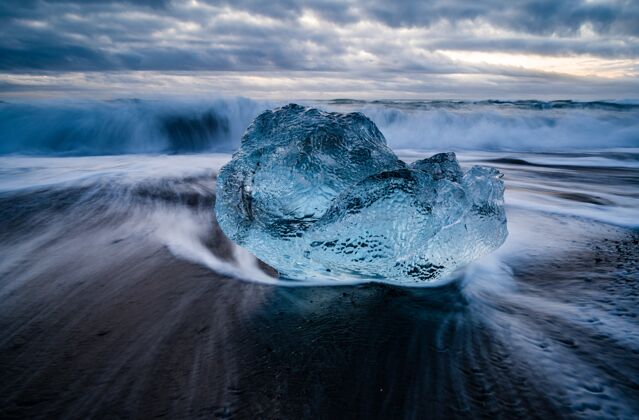 岩石特写镜头的冰河泻湖在冰岛与波浪大海的背景Swoosh天空冰川