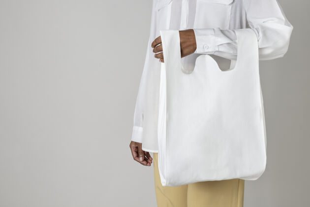 购物袋黑人妇女拿着一个白色可重复使用的购物袋携带杂货袋女士