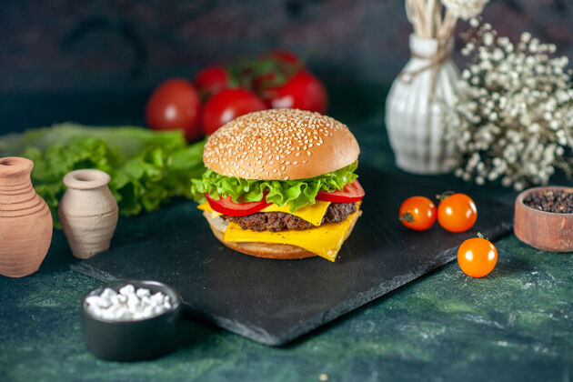 正餐前视图美味的肉汉堡包与红色西红柿在黑暗的背景深色健康汉堡