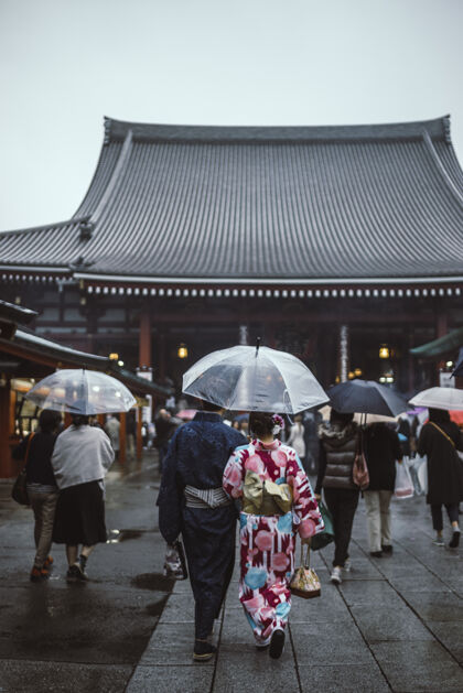日期人们撑着雨伞走在街上去宝塔树冠人日本