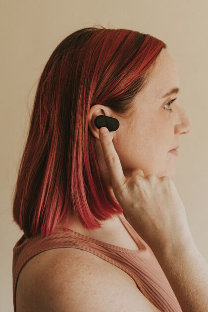 耳机戴着无线耳塞的粉红头发女人打开商业人