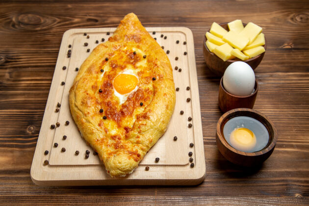 早餐正面图棕色桌子上的新鲜烤面包和熟鸡蛋面团食物早餐烤面包面团午餐奶酪