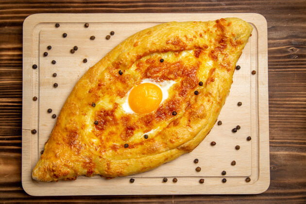 鸡蛋顶视图新鲜烤面包配煮熟的鸡蛋放在棕色木制书桌上面团早餐鸡蛋包食物早餐新鲜馒头