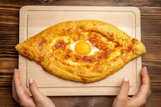生的顶视图木桌上的新鲜烤面包和熟鸡蛋面包面团面包食物早餐鸡蛋面包烘焙桌子
