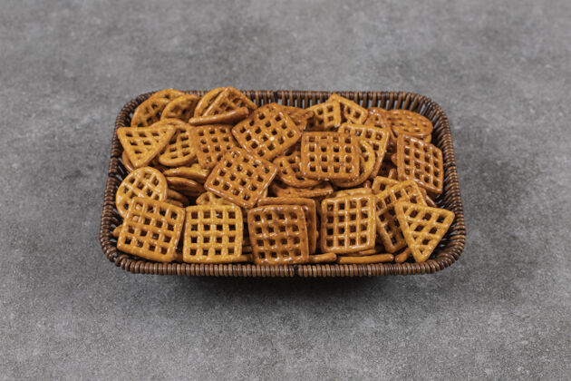 桌子篮子里的饼干堆在灰色的表面上新鲜条纹饼干