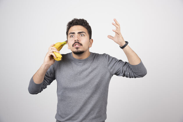 人类拿着香蕉当电话的黑发男人情感水果指向