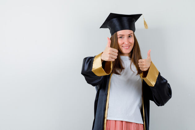 表演一个穿着休闲服 穿着制服 看起来很快乐的女毕业生竖起了大拇指正视图成就大学单身