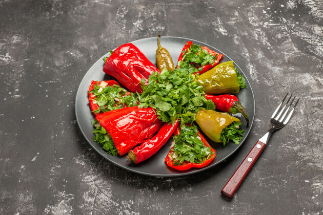 胡椒盘侧面特写辣椒盘开胃的五颜六色的辣椒与草药叉子特写壁板午餐