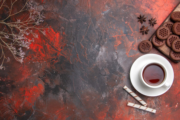古董俯瞰一杯茶与巧克力饼干在深色餐桌上的颜色仪式茶深色饼干垃圾碗