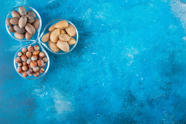 碗各种各样的坚果放在蓝色的碗上蛋白质健康自然
