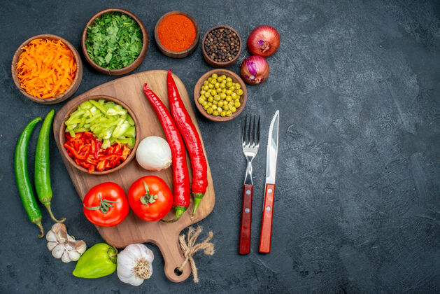胡椒在一张深色的桌子上俯瞰新鲜蔬菜和绿豆成熟的沙拉蔬菜黑西红柿沙拉