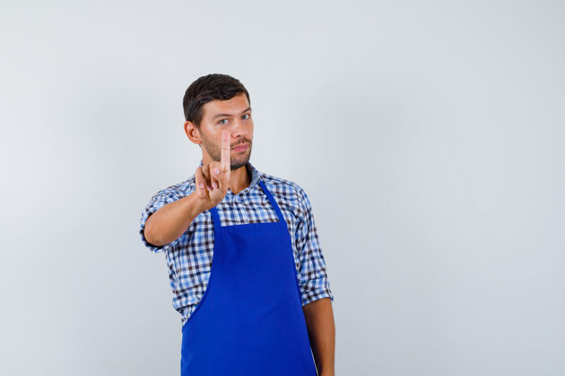 成人穿着蓝色围裙和衬衫的年轻男厨师帅哥男士男士