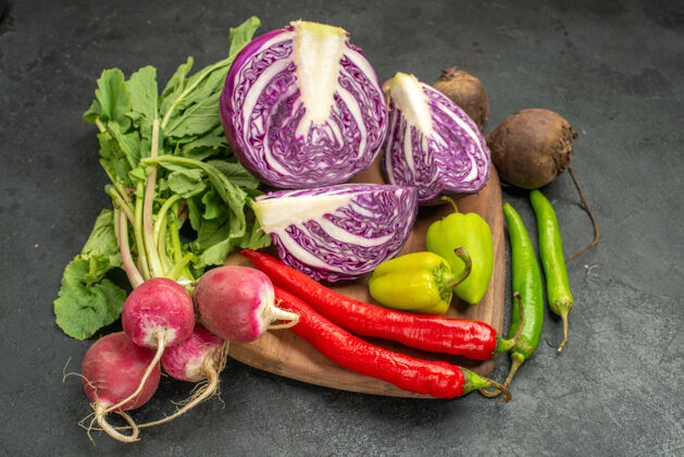 食物前视图新鲜的红色卷心菜搭配其他蔬菜上深色餐桌沙拉饮食健康成熟健康农产品新鲜的红白菜