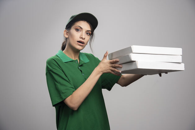 送货年轻的女信使摆出披萨盒的姿势承运人咖啡女性