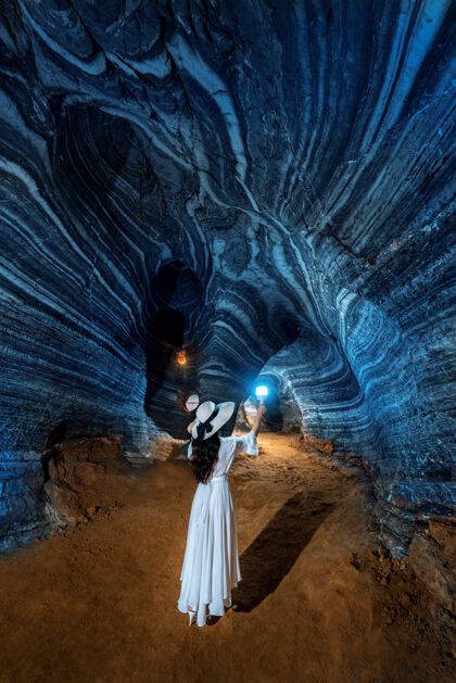回来美丽的白衣女孩漫步在泰国的蓝洞石头墙旅游