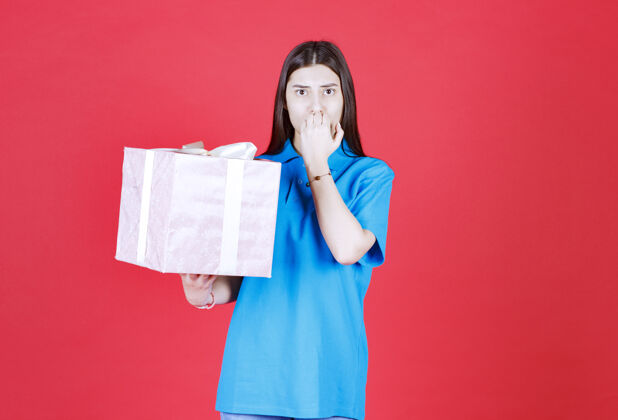 女人一个女人拿着一个紫色的礼盒 看起来很困惑 很有思想不确定激动礼物