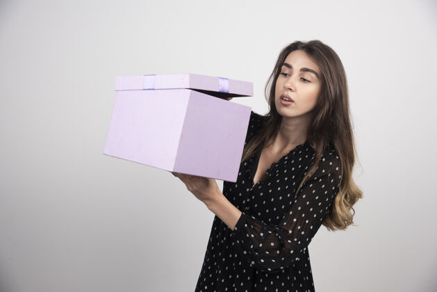 年轻人看紫色礼盒的年轻女子女性礼物模特
