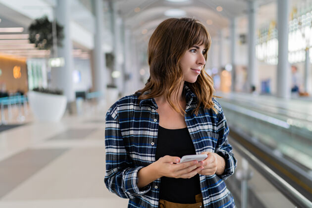手机女性用智能手机穿过机场旅游女性智能
