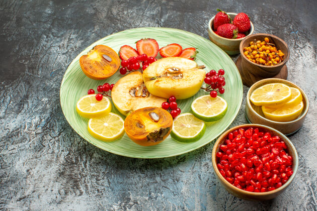 健康前视图新鲜水果 木瓜 柠檬和其他水果放在浅色桌上甜点膳食清淡