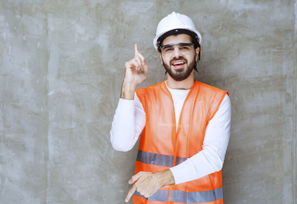 促销戴着白色头盔和防护眼镜的工程师上下指指点点人雇员方向