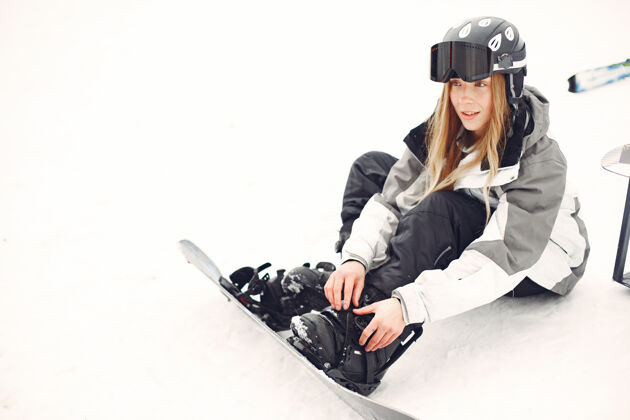 一个穿着滑雪板套装的女人在山上手拿滑雪板的运动员在地平线上关于运动的概念自然冬天女