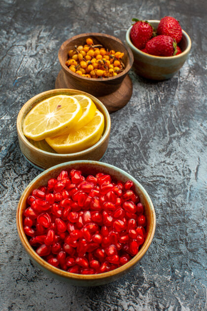 饮食正面图剥皮的石榴与其他水果放在一张深色浅色的桌子上 新鲜水果的颜色农产品红葡萄干配料