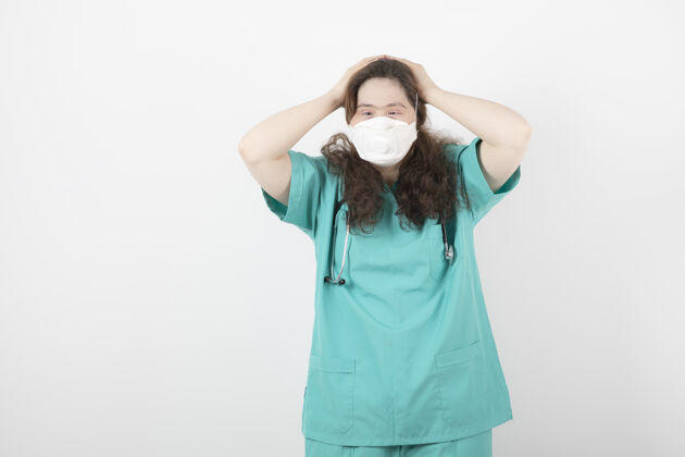 女人穿着绿色制服戴着医用口罩的年轻女子医学听诊器模特