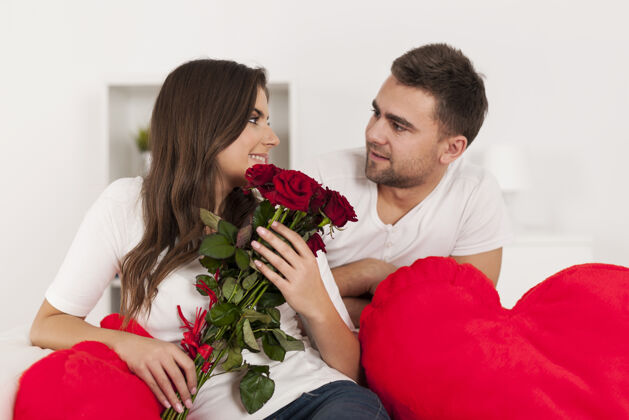 年轻夫妇红玫瑰情侣快乐地板约会讨论